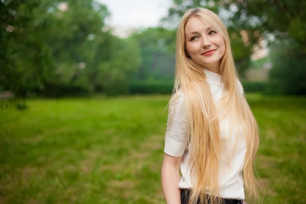 Flicka ute i parken med långa blonda hår — Stockfoto