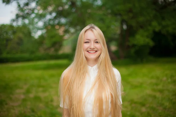 Девушка в парке с длинными светлыми волосами — стоковое фото