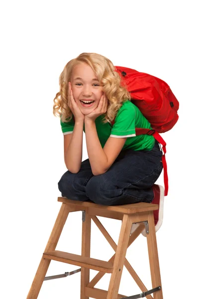 Маленькая блондинка в зеленой футболке с красной сумкой — стоковое фото