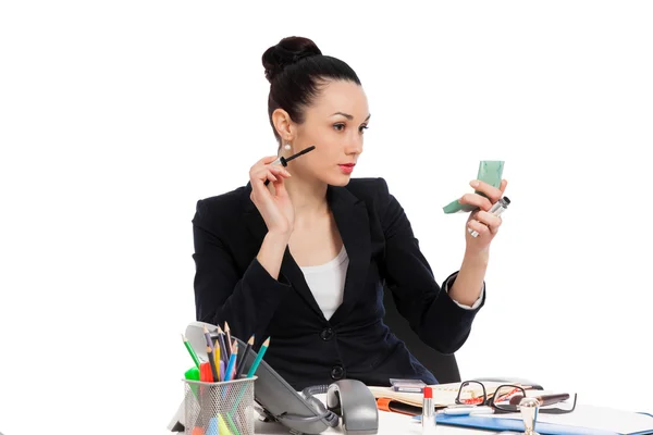 Brunette zakenvrouw zetten haar make-up op het werk — Stockfoto