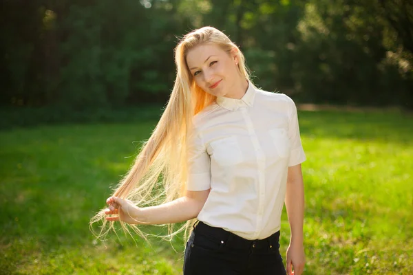 Κορίτσι έξω στο πάρκο με μακριά ξανθά μαλλιά Royalty Free Εικόνες Αρχείου