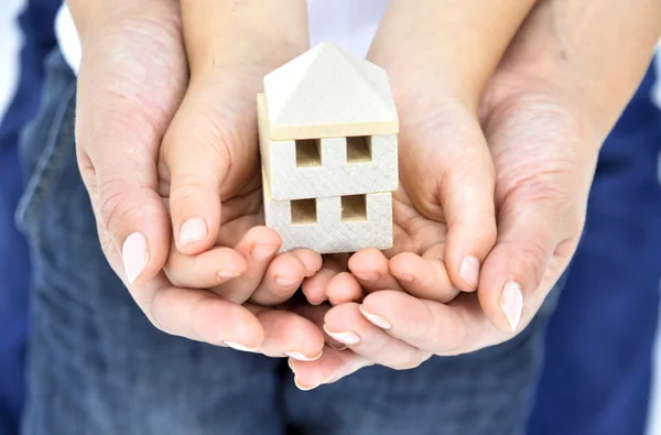 Adult's Hand holding Child's Hands and Model of the House — Stock Photo, Image