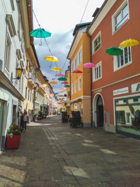 Avusturya 'nın Villach kasabasında yüzen şemsiyeli Lederergasse renkli caddesi