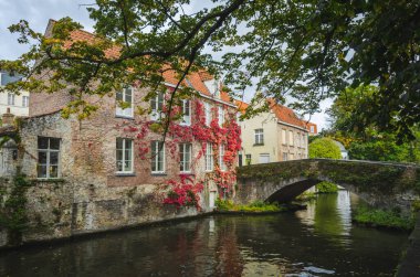 Bruges 'ün tarihi şehir merkezi ortaçağ tuğla mimarisi bir kanalın suyuna yansıyor.
