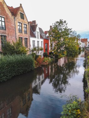 Bruges 'ün tarihi şehir merkezi ortaçağ tuğla mimarisi bir kanalın suyuna yansıyor. 