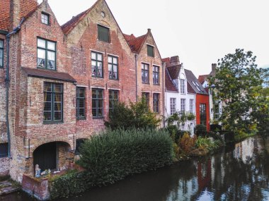 Bruges 'ün tarihi şehir merkezi ortaçağ tuğla mimarisi bir kanalın suyuna yansıyor. 