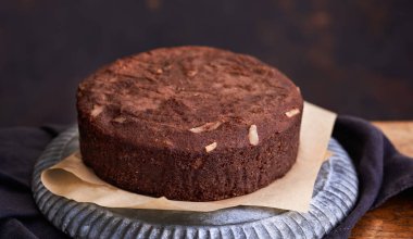 Sağlıklı çikolatalı pasta, badem şekersiz, eski ahşap arka planda bir tabakta. Seçici odaklanma. Keto diyeti.