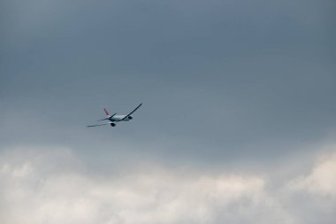 One plane flying on a cloudy sky. 