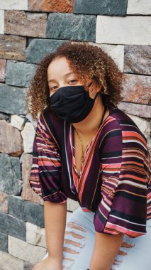 Kız karantinayı bitirdikten sonra maskesiyle dışarı çıkıyor.