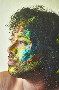  Sanatı temsil eden yüzü birçok renge boyanmış bir çocuk.                                    