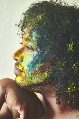  Sanatı temsil eden yüzü birçok renge boyanmış bir çocuk.                                    