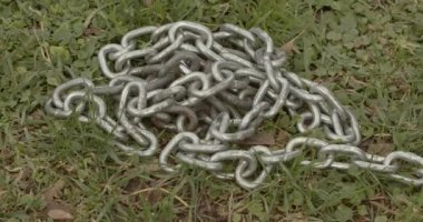 Çimlerin üzerindeki zinciri açıyorum. Belki de köpek kaçıyordur.