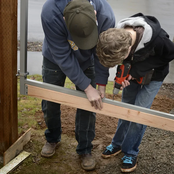 Père et Fils Construire une Porte Image En Vente