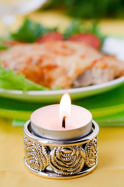 Kerze im Hintergrund gebackenes Fleisch mit Pilzen. Tischservice. — Stockfoto