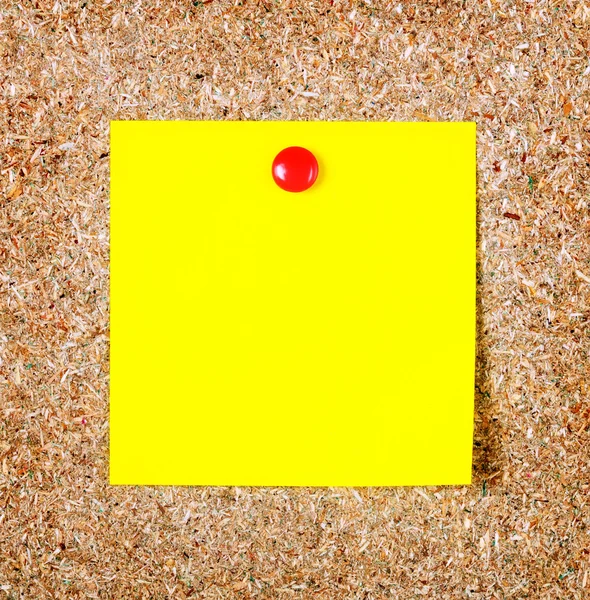 Yellow note paper on a cork board. Closeup — Stock Photo, Image