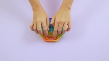 Çocukların elleri modern silikon oyuncağın üzerine baloncuk bastırıyor. Stres önleyici oyuncaklar, popit ve basit gamzeler. 4K görüntü.