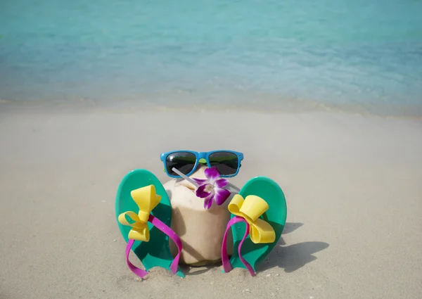 Coconut with drinking straw on a beach — Stock Photo, Image