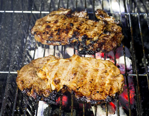 Hovězí steak na grilu s plamenama. — Stock fotografie