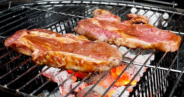 Stek wołowy na grillu z płomieniami. — Zdjęcie stockowe