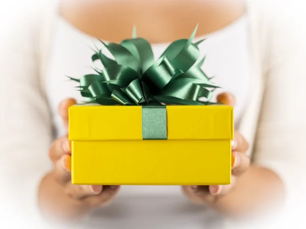 Female hands holding gift with ribbon. — Stock Photo, Image
