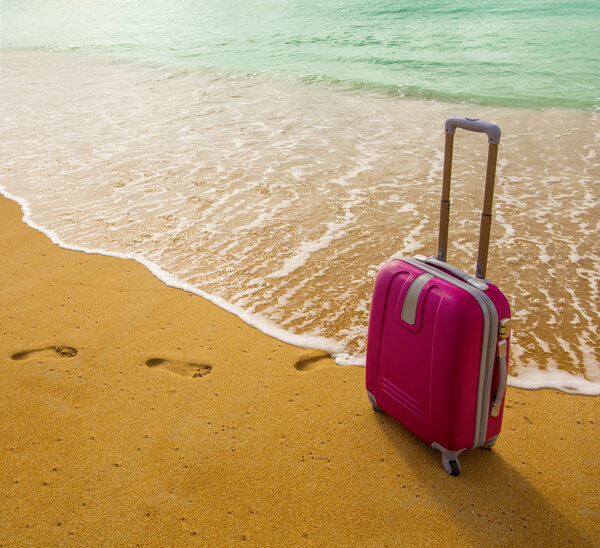 Suitcase on the beach with white sand