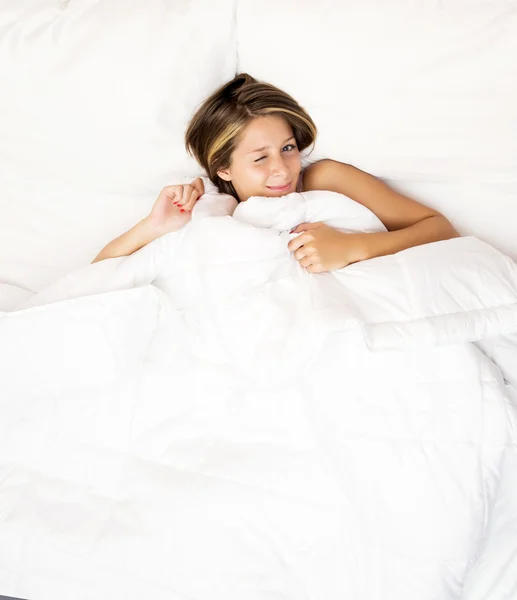 Ung kvinna som sover på den vita lin i sängen — Stockfoto