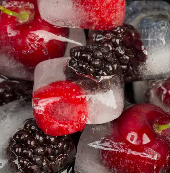 Fresh fruits frozen in ice cubes — Stock Photo, Image