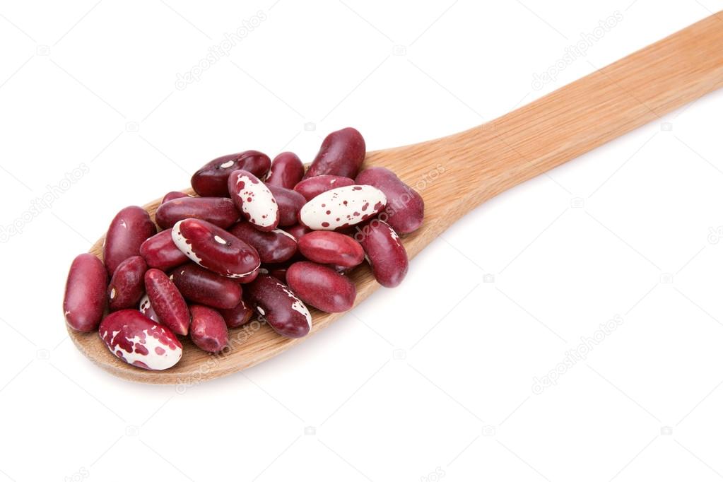 Beans in a pile on a white background in a wooden spoon