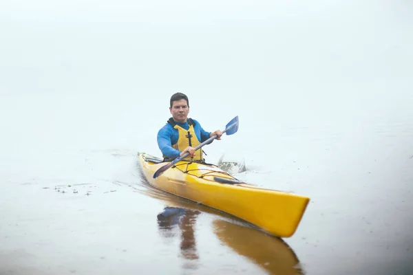 秋の霧の川でカヤックを漕いでいる男がいる — ストック写真