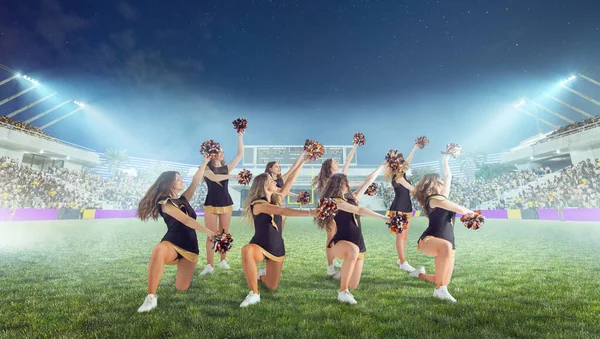 Group of cheerleaders in action on  stadium in night