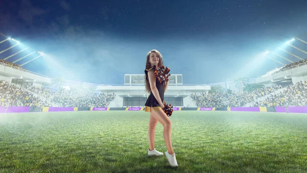 Beautiful cheerleader in action on stadium in night