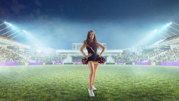 Beautiful cheerleader in action on stadium in night