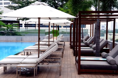 şezlong ve yüzme havuzunun condominium yüksek katlı binada cabanas