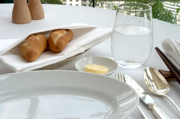 Bread and china plate and table setting in high-class restaurant — Stock Photo, Image