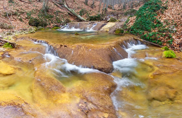 Creek with waterfall and yellow stone. — Stock Photo, Image