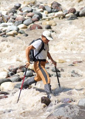 turist çalkantılı nehir geçer
