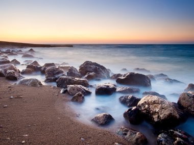 gün batımı sırasında su yansımaları ile deniz kıyısı.