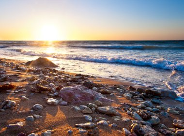 gün batımı sırasında su yansımaları ile deniz kıyısı.