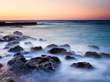 gün batımı sırasında su yansımaları ile deniz kıyısı.