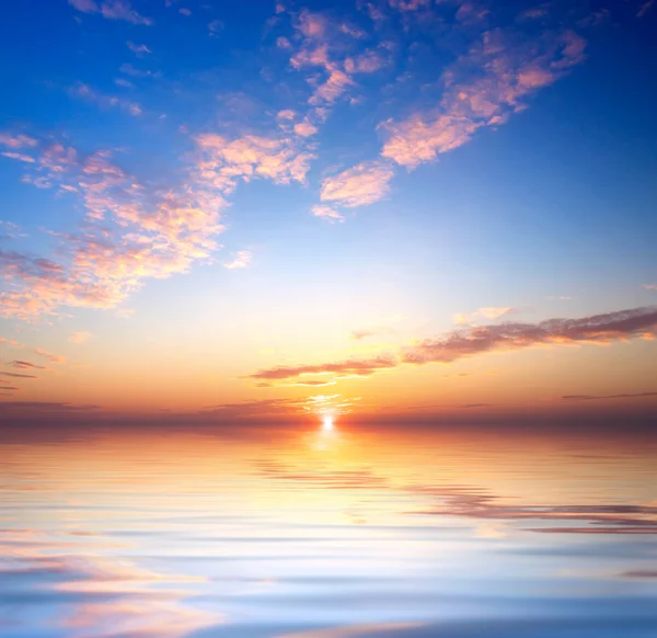 Kust met reflecties in water tijdens zonsondergang. — Stockfoto