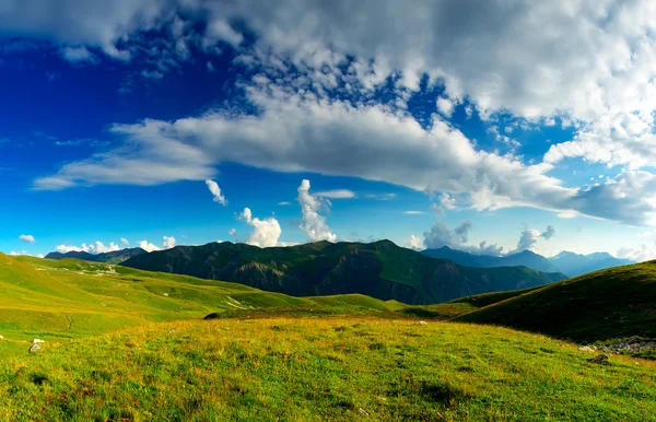 Colinas verdes e céu com nuvens . — Fotografia de Stock