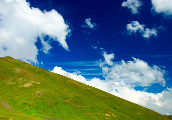 Colinas verdes y cielo con nubes . — Foto de Stock