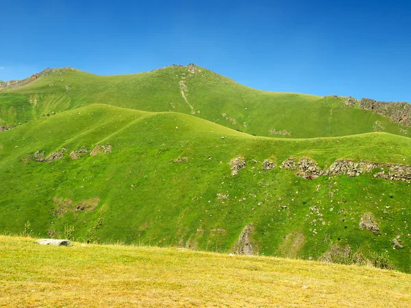 Zielone wzgórze w górskiej dolinie. — Zdjęcie stockowe
