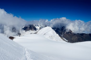 kayalar ve gökyüzü beyaz bulutlar ile.