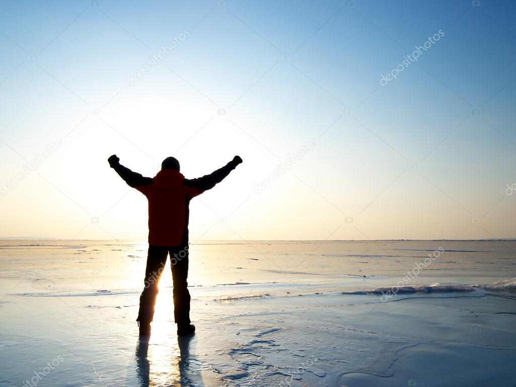 Man on the glacier in front of the sun