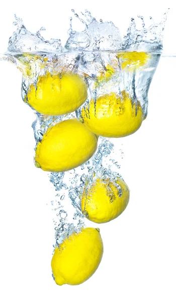 Limões amarelos brilhantes e salpicos de água Imagens Royalty-Free