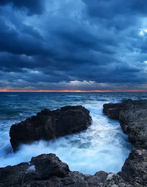 Deniz taş ve parlak gökyüzü gün batımı sırasında — Stok fotoğraf