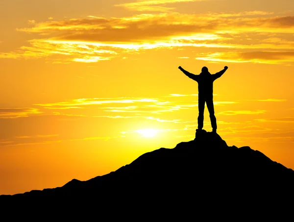 Silhouette of the winner on the high rock — Stock fotografie