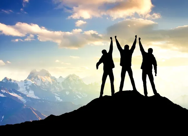 Silueta del equipo en la cima de la montaña — Foto de Stock