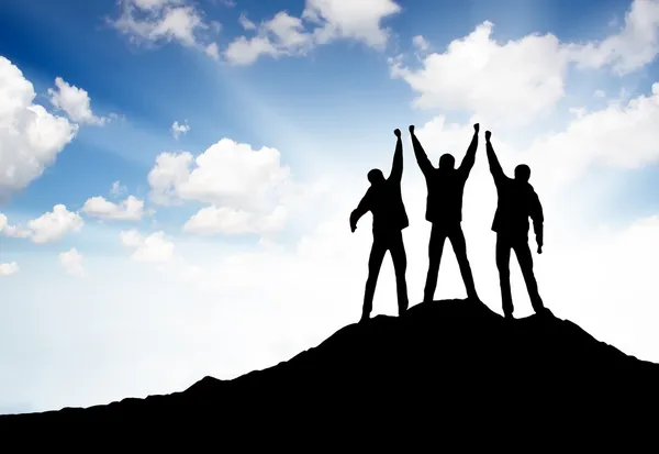 Silueta del equipo en la cima de la montaña — Foto de Stock